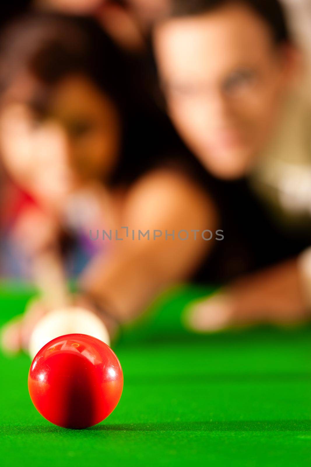 Couple (man and woman) in a billiard hall playing snooker