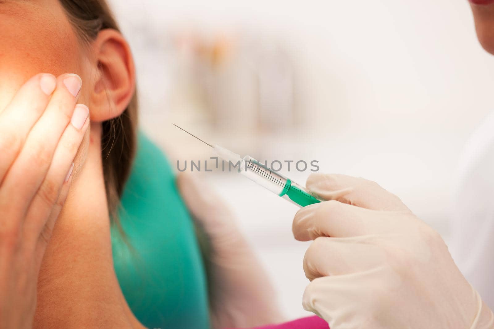 At the dentist - a female patient is getting ready to receive a anesthetization syringe (focus on syringe)