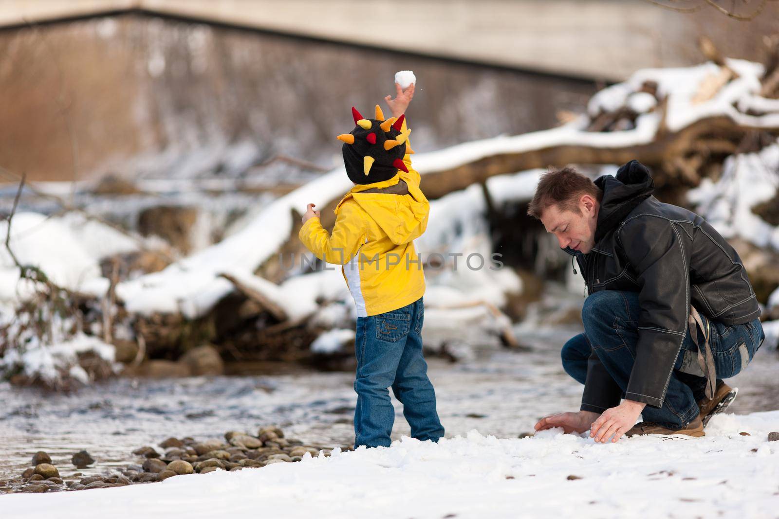 Family having winter walk at river by Kzenon
