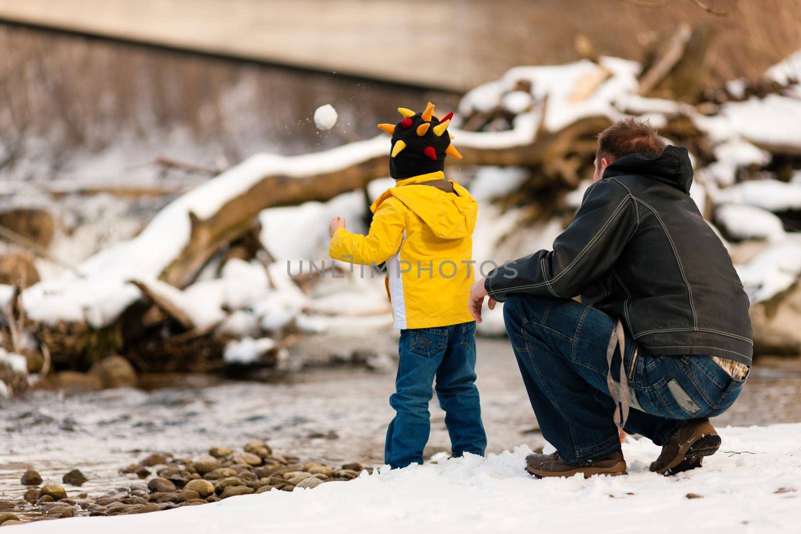 Family having winter walk at river by Kzenon