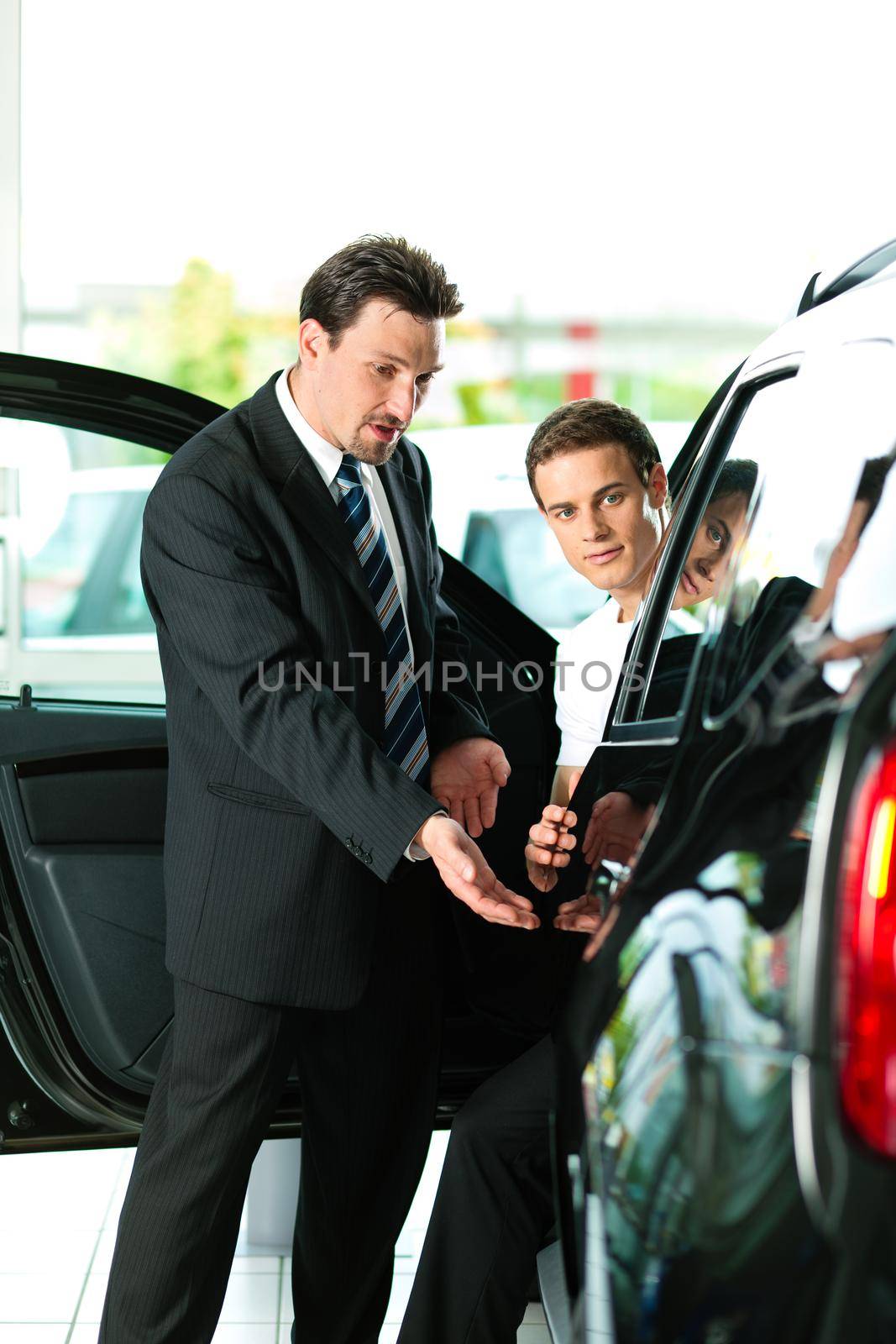 Man buying car from salesperson by Kzenon