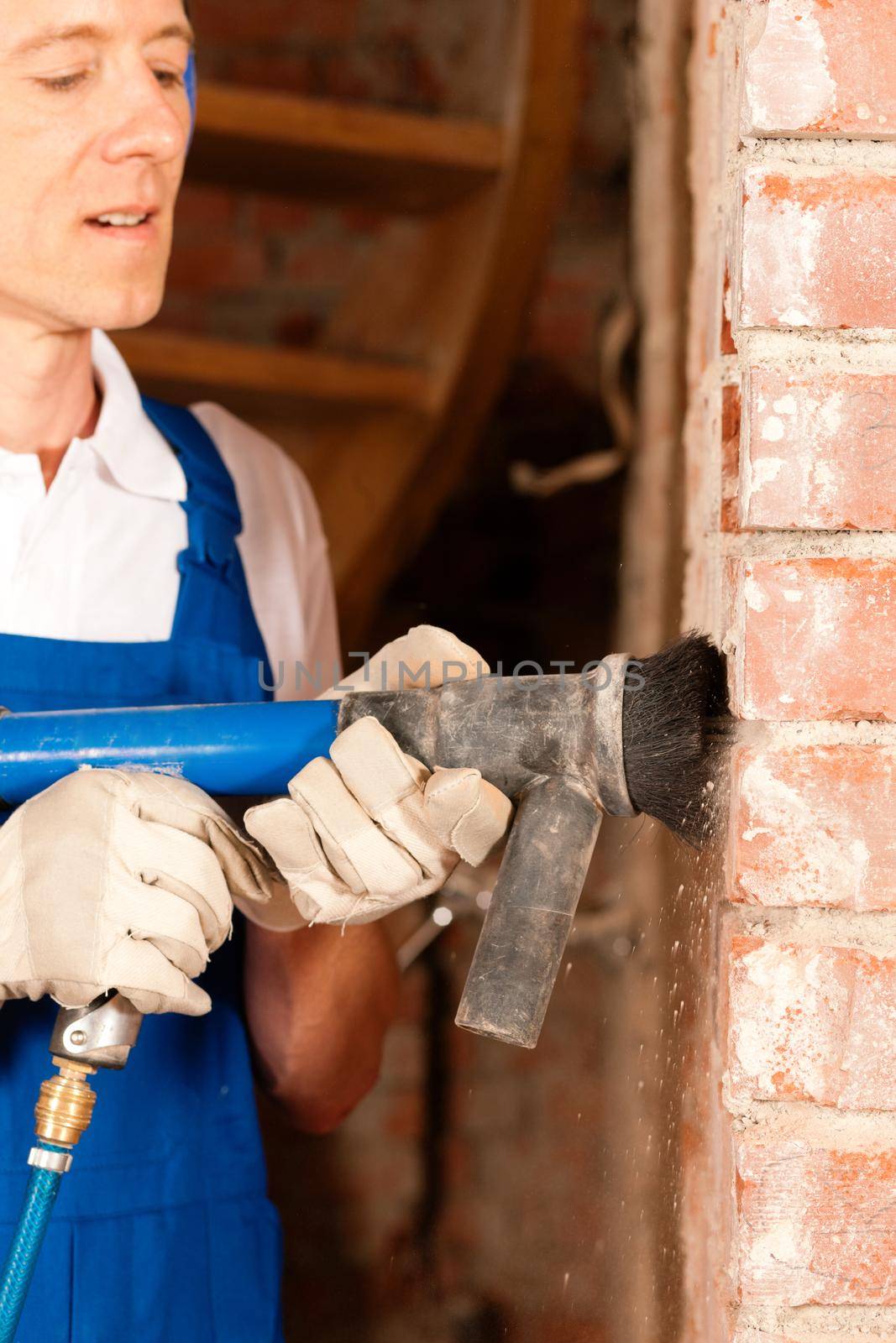 Construction worker removing plaster by Kzenon