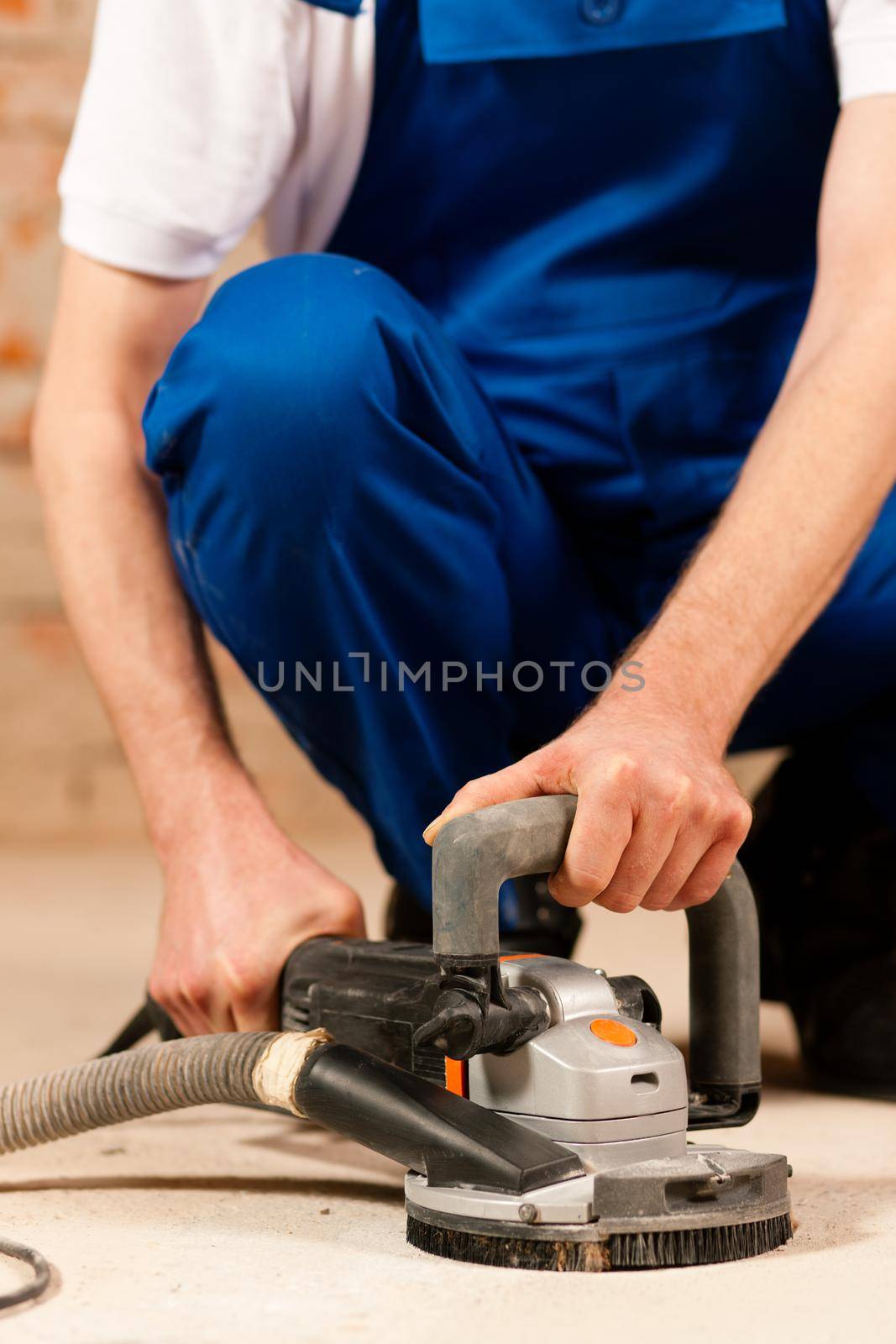 Construction worker working grinding the cement floor