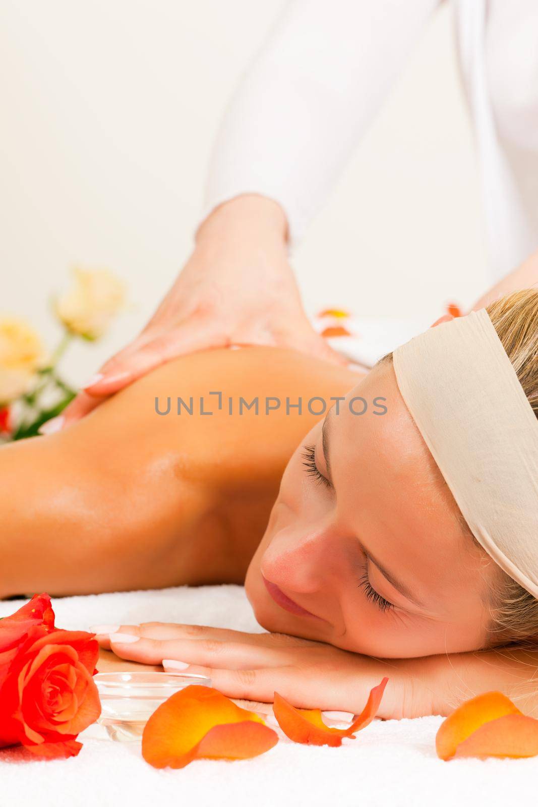 Woman enjoying a wellness back massage in a spa, she is very relaxed (close-up)