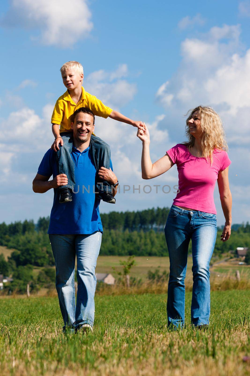 Family having walk on meadow by Kzenon