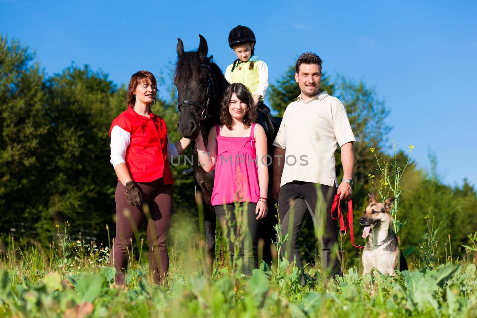 Family with children posing with a horse, one child riding the animal