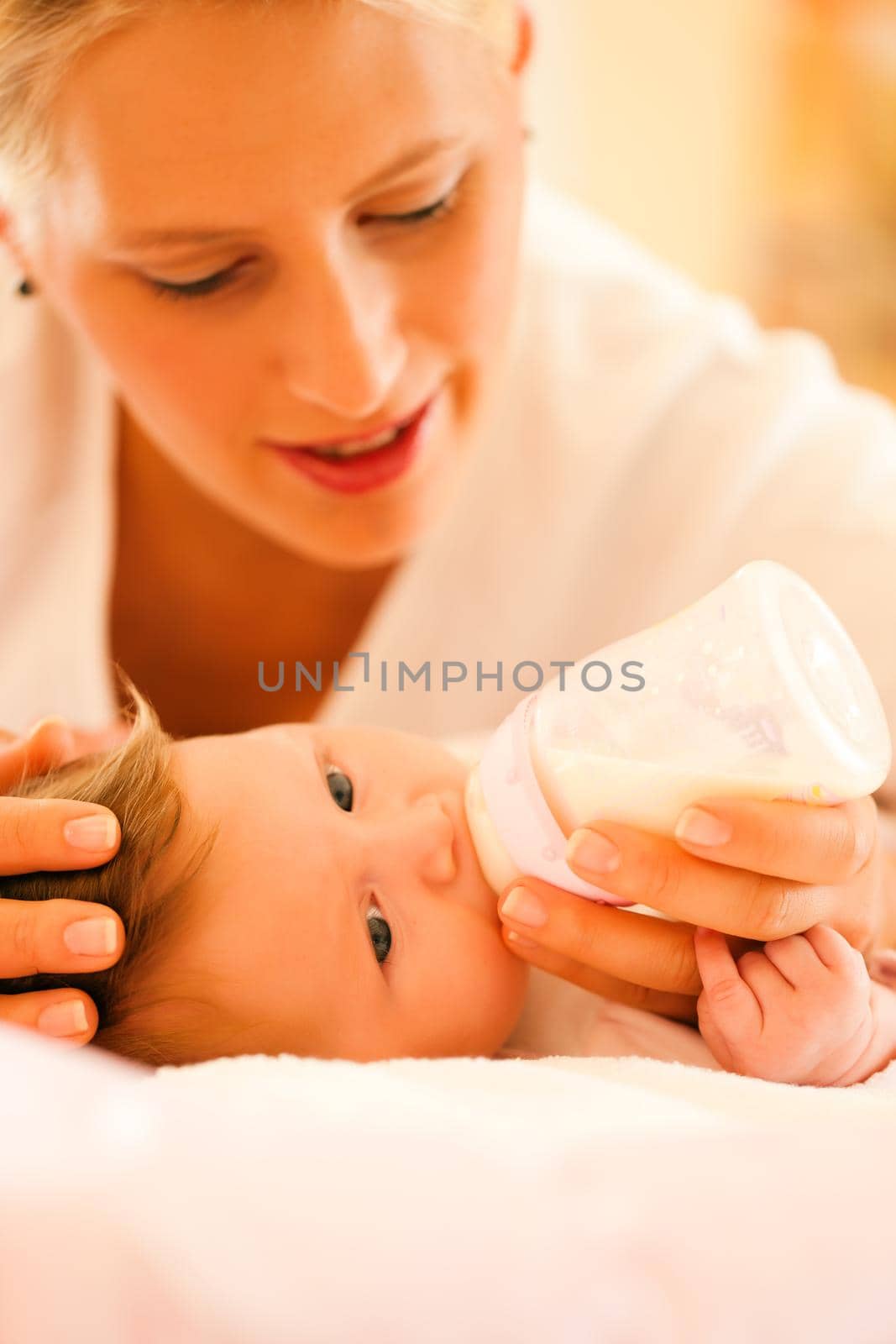 Mother is feeding her baby with a bottle; very tranquil scene