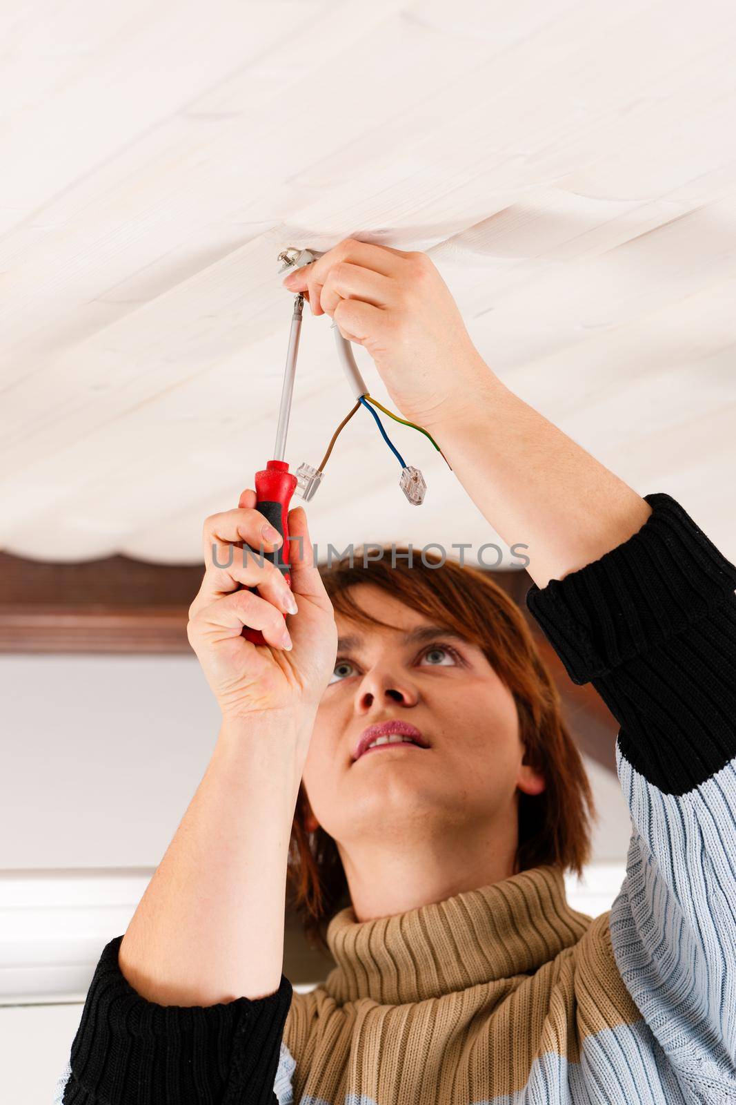 Female worker doing work on electrical installation