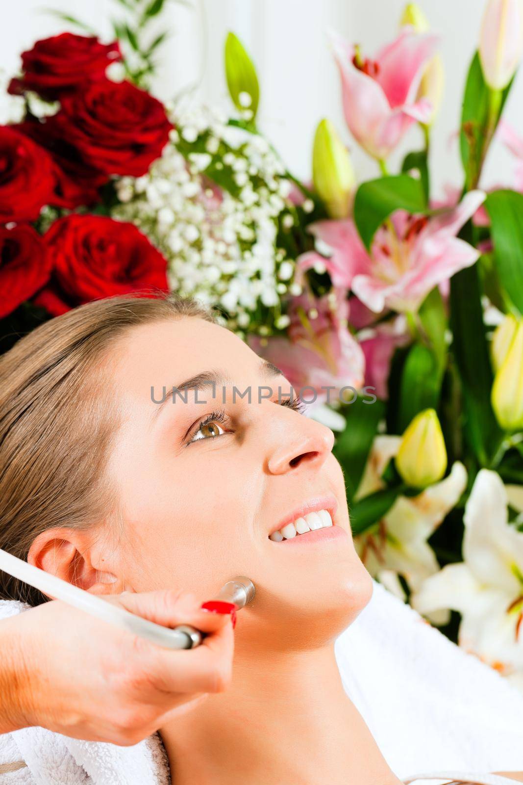 Woman receiving beauty treatment in a Day Spa; lots of flowers in the background