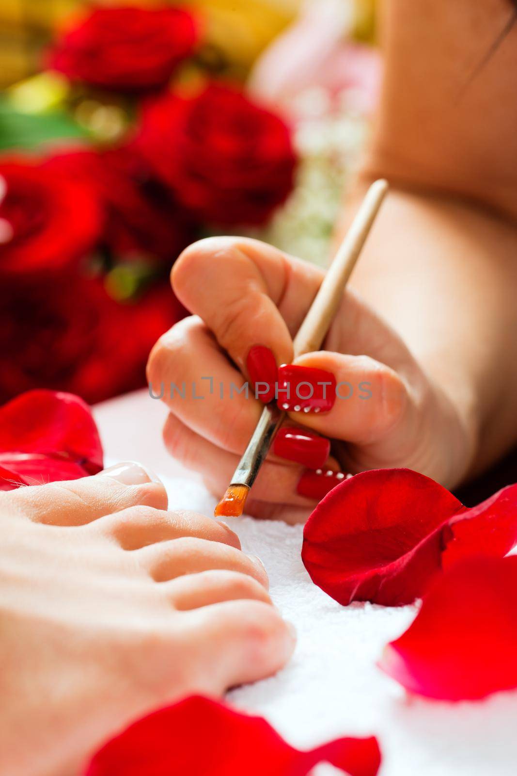 Woman receiving pedicure in a Day Spa; lots of flowers in the background