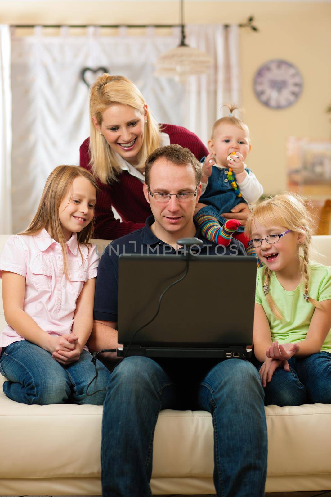 Young family in front of computer with camera having a video chat