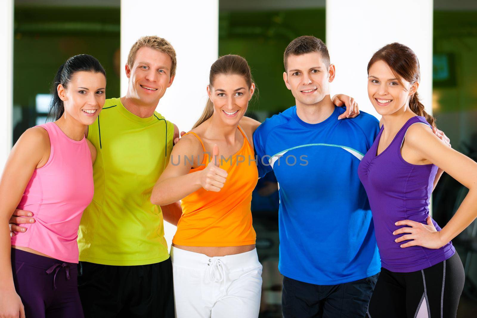 Group of five people exercising in gym or fitness club