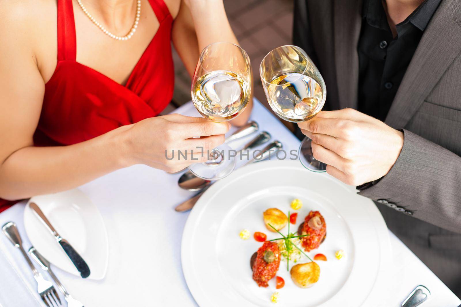 Couple for romantic Dinner or lunch in a gourmet restaurant drinking white wine and having great food