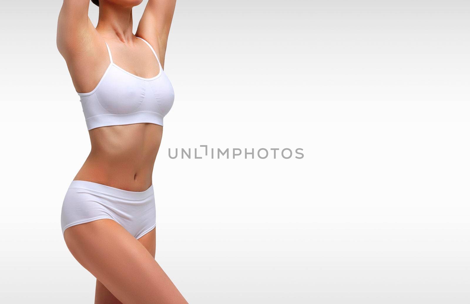 Sexy woman with slim lovely body. Liposuction, diet and healthy lifestyle, weight loss concept. Grey background with copyspace by Nobilior