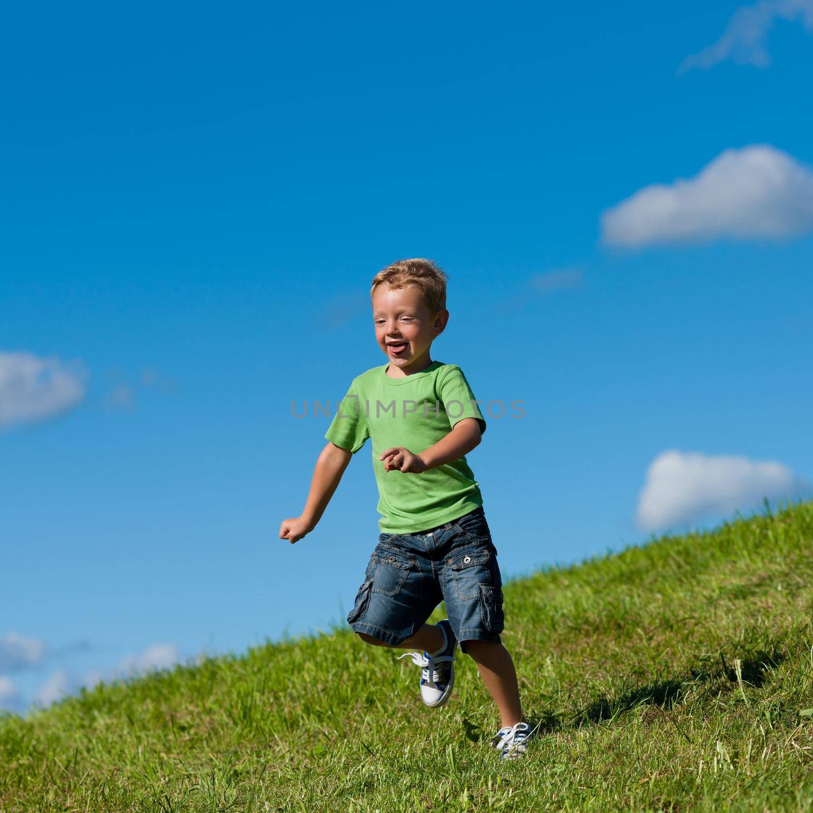 Boy running down a meadow by Kzenon