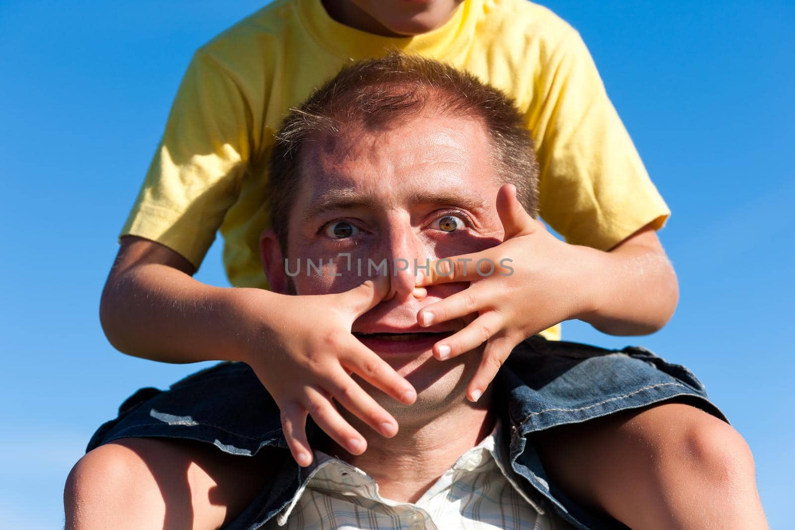 Father and son, he is carrying the son on the shoulders and they do have lots of fun