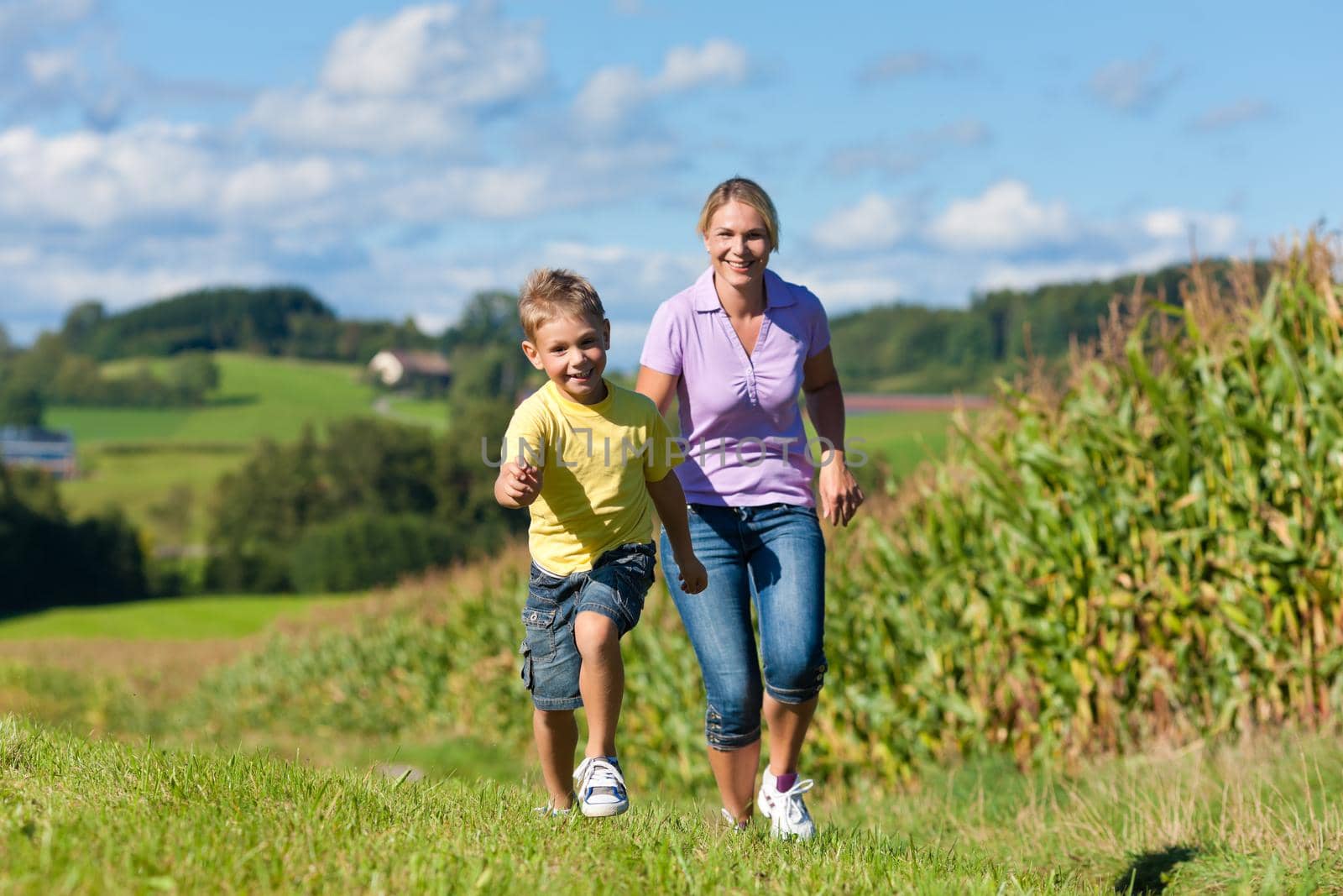 Family outdoors is running on a meadow by Kzenon