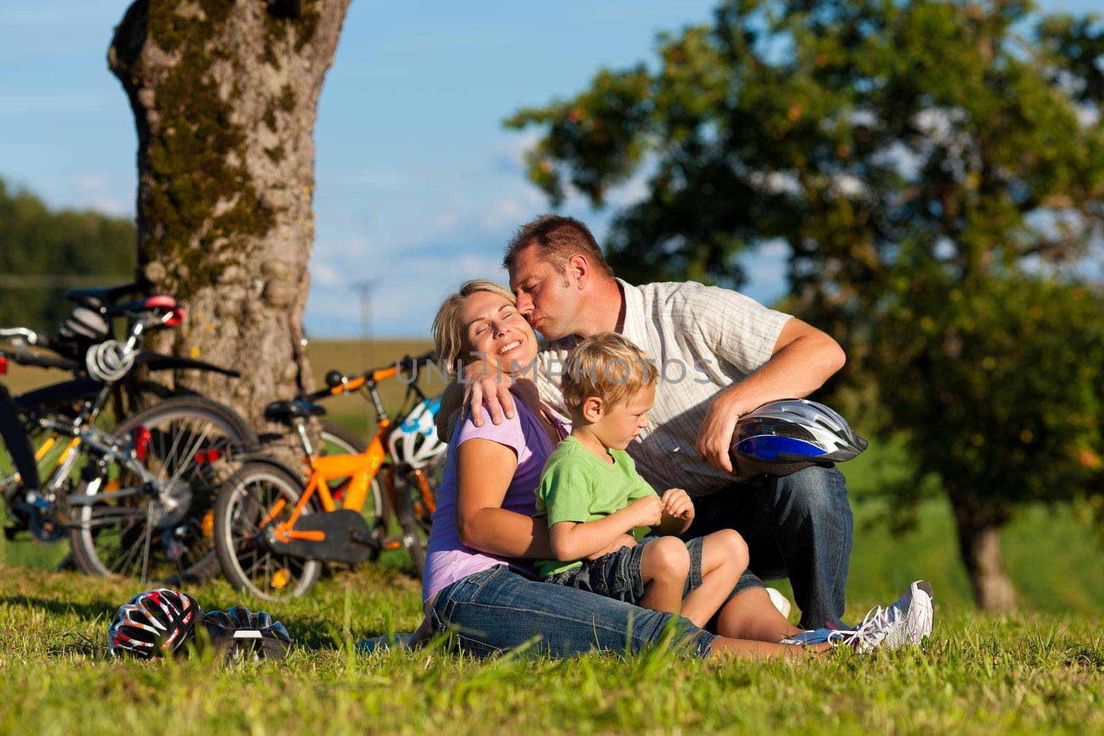 Happy family (father, mother and son) on getaway with bikes - they have a break