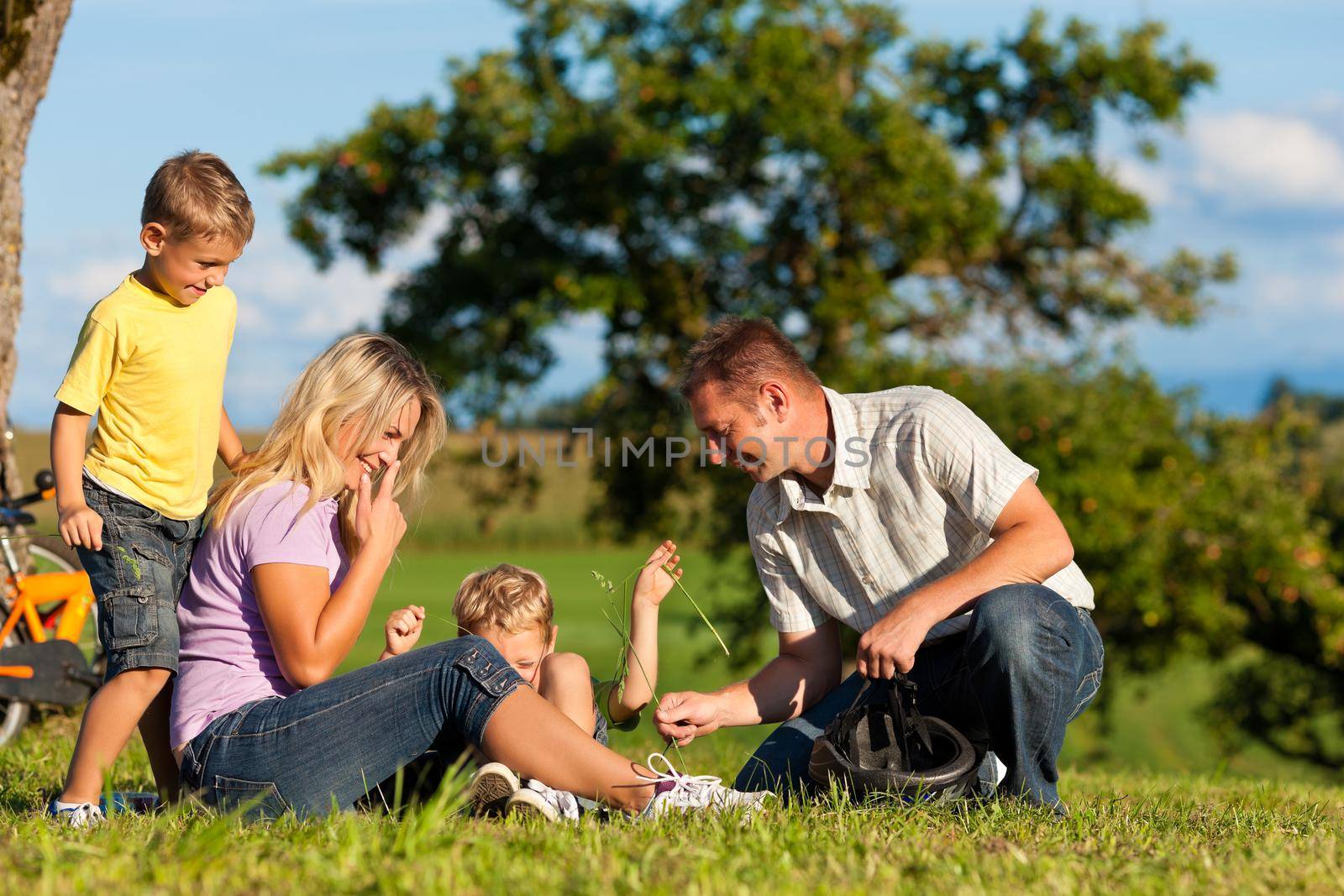 Happy family (father, mother and two sons) on getaway with bikes - they have a break