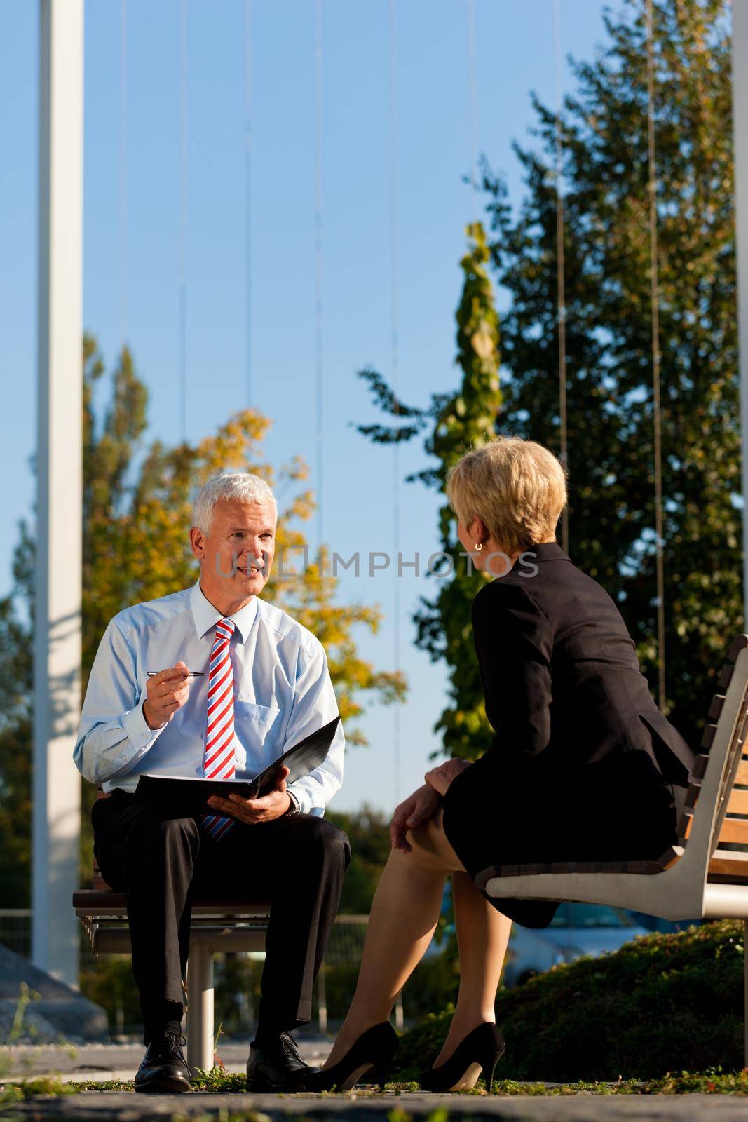 Business Coaching outdoors - man and woman in coaching discussion