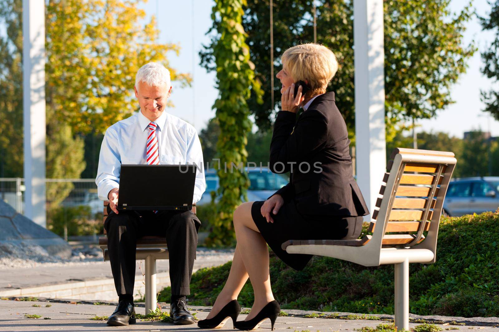 Business people working outdoors by Kzenon