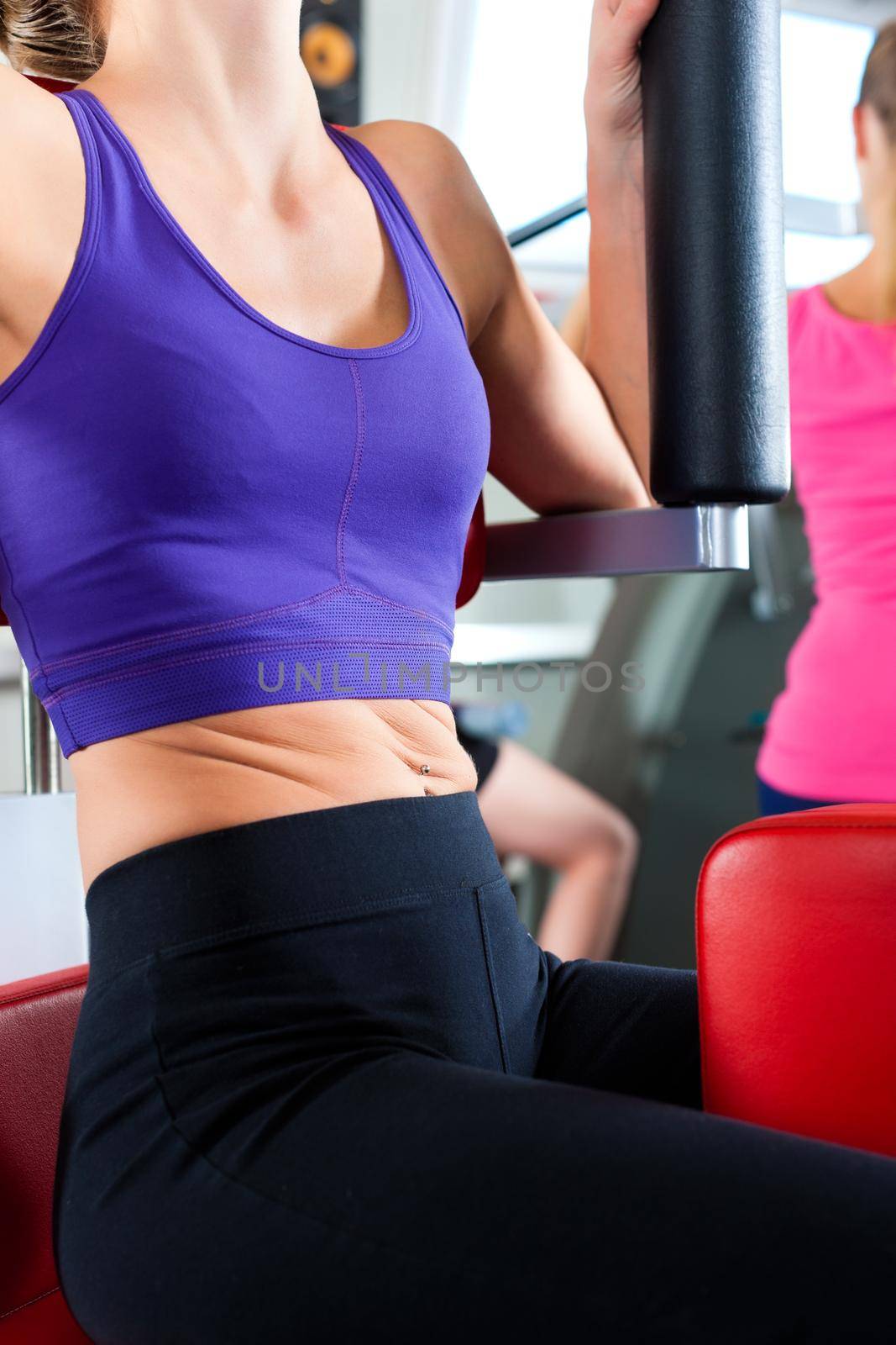 Three young women doing strength or sports training in gym for a better fitness, close-up