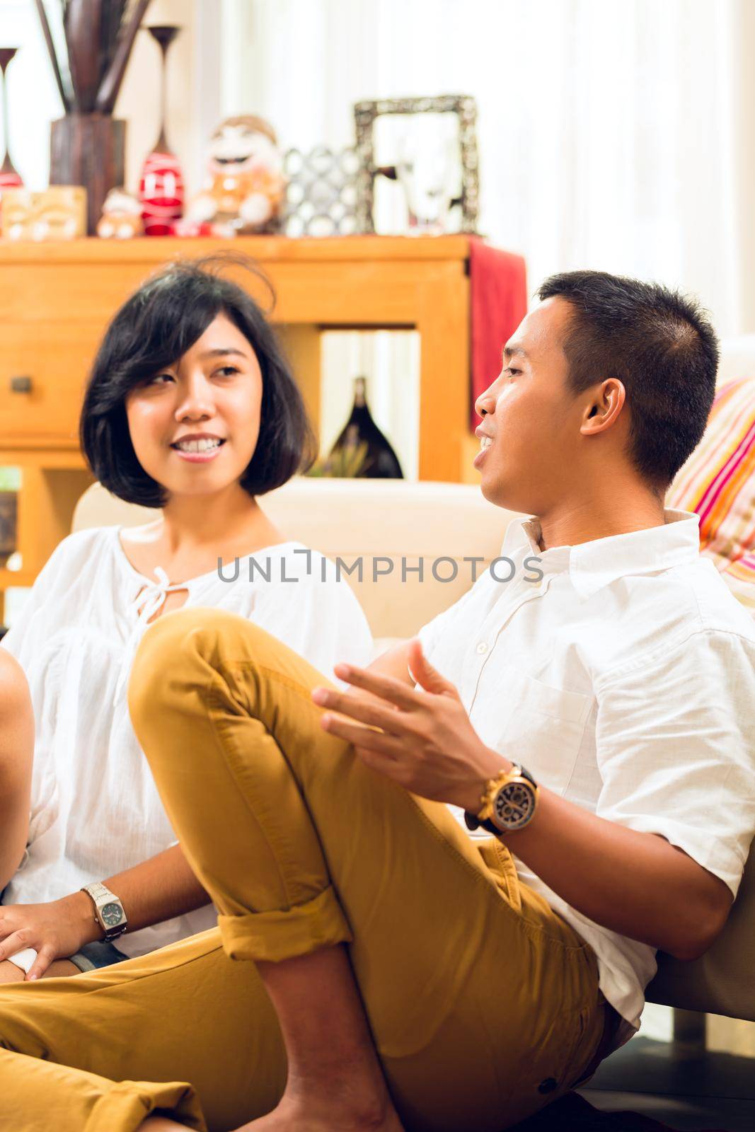 Asian couple in their living room talking to each other