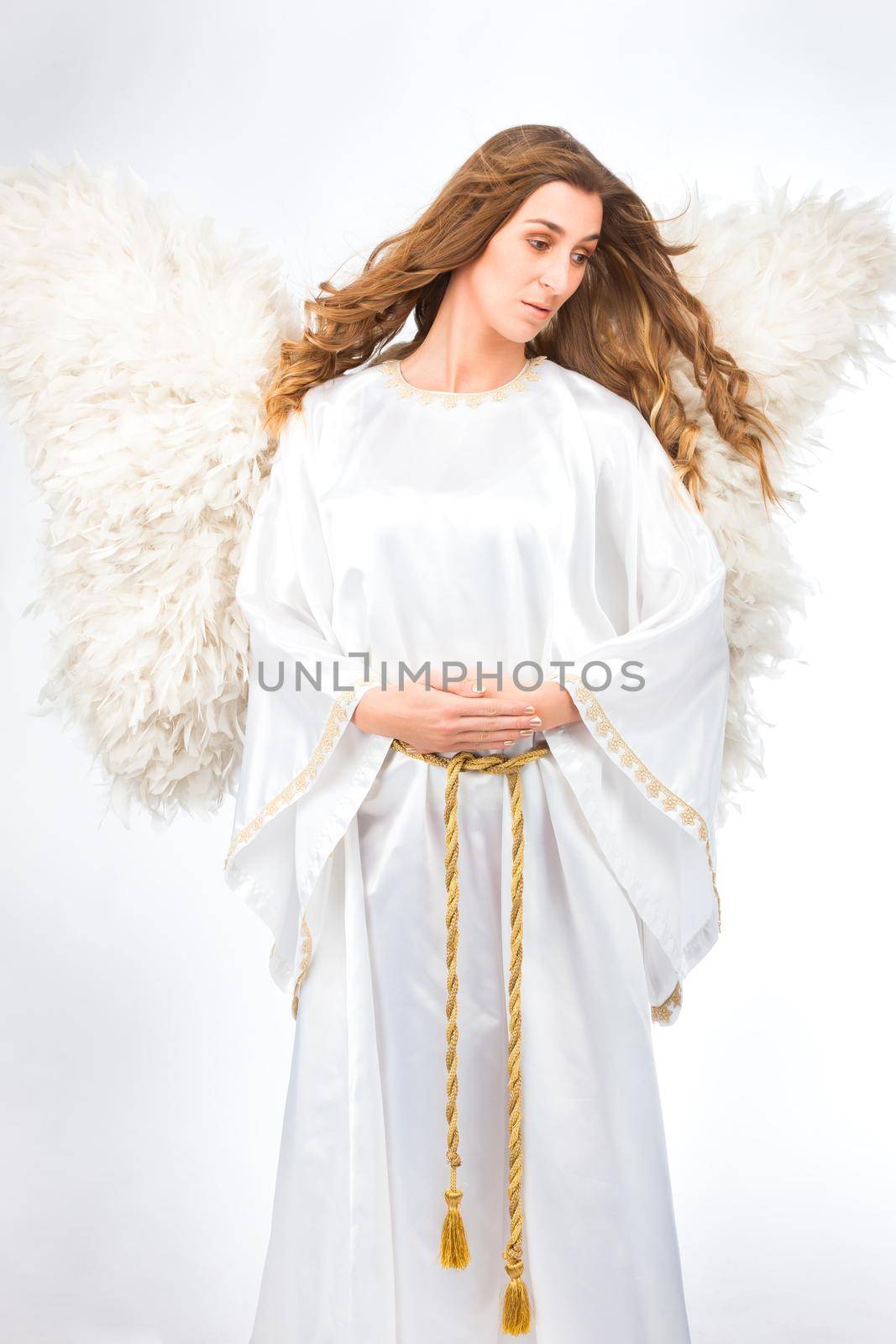 Woman in angel costume with artificial feather wings isolated on white background spirituality purity dreams religion