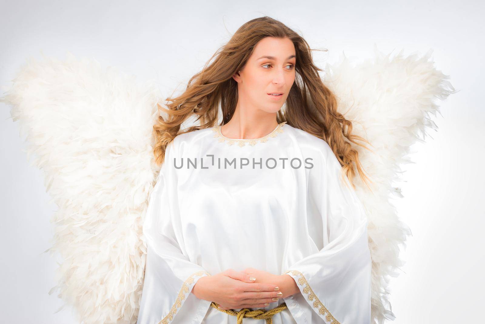 Woman in angel costume with artificial feather wings isolated on white background spirituality purity dreams religion