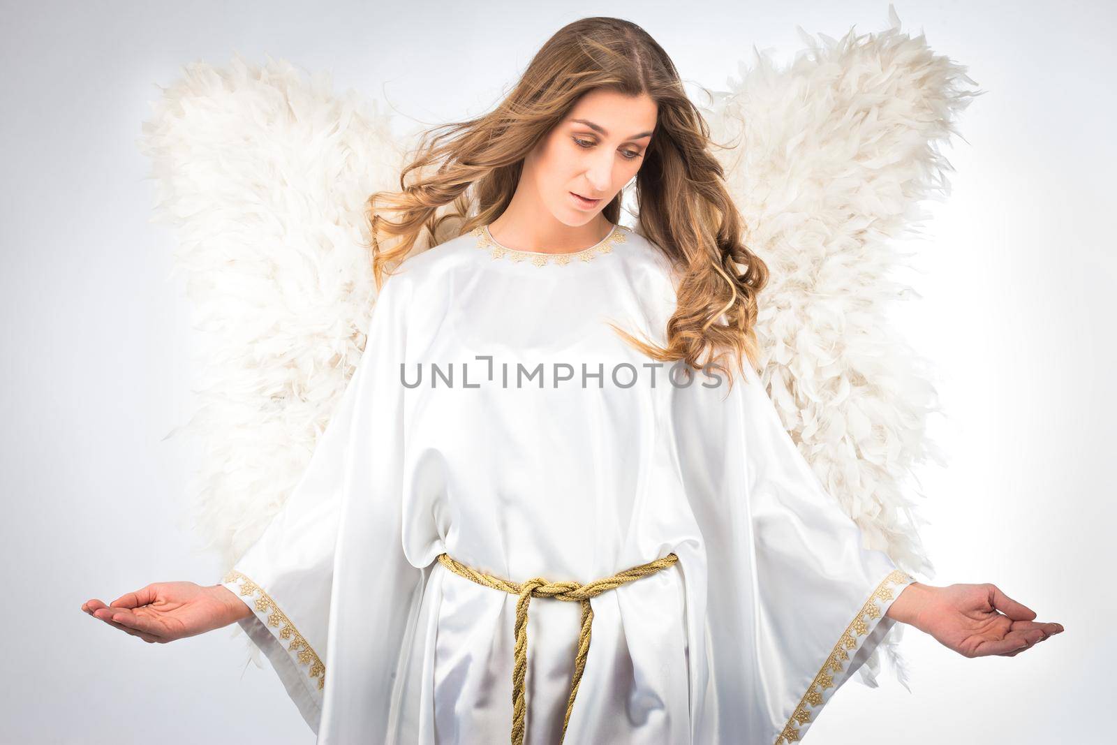 Woman in angel costume with artificial feather wings isolated on white background spirituality purity dreams religion