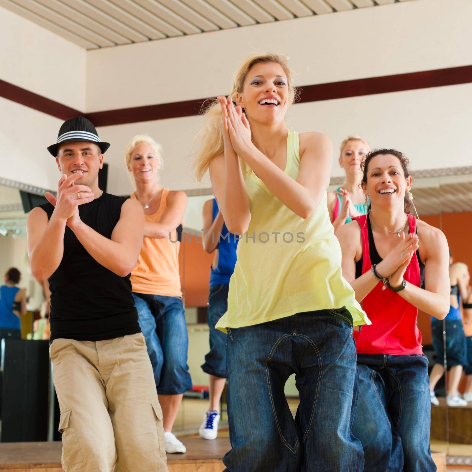 Zumba or Jazzdance - young people dancing in a studio or gym doing sports or practicing a dance number