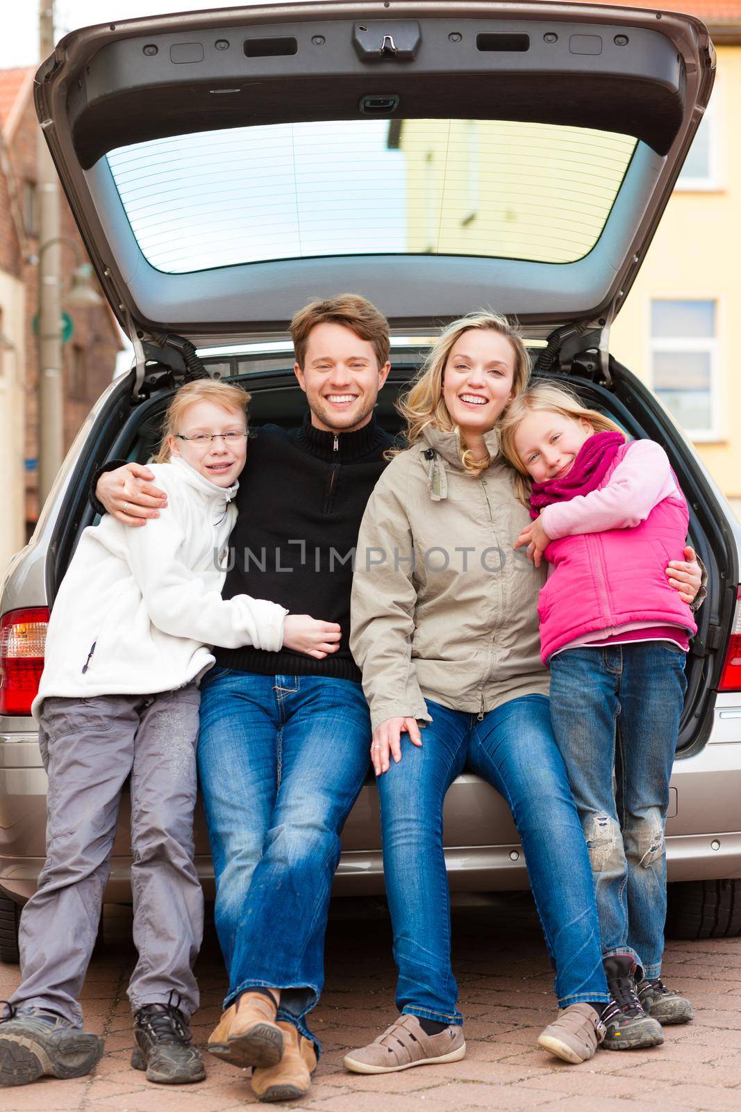 Family, mother, father and children, sitting in the trunk, they make a trip