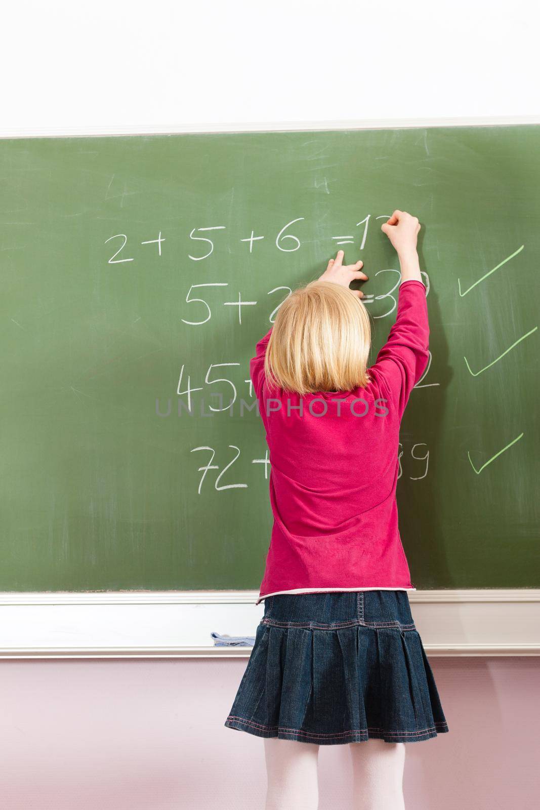Education - Child or pupil at blackboard in school in maths
