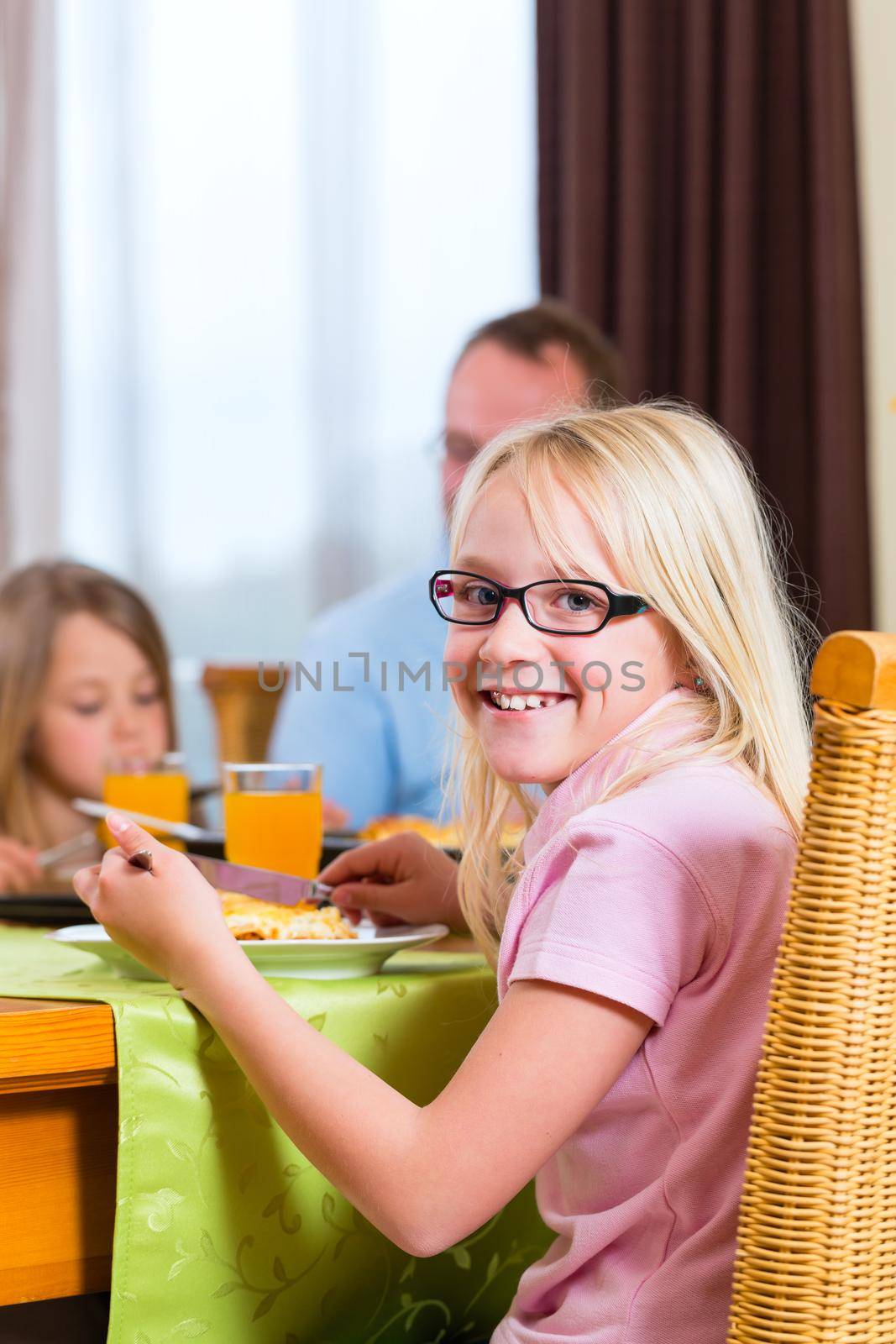 Family eating lunch or dinner and sitting at the table