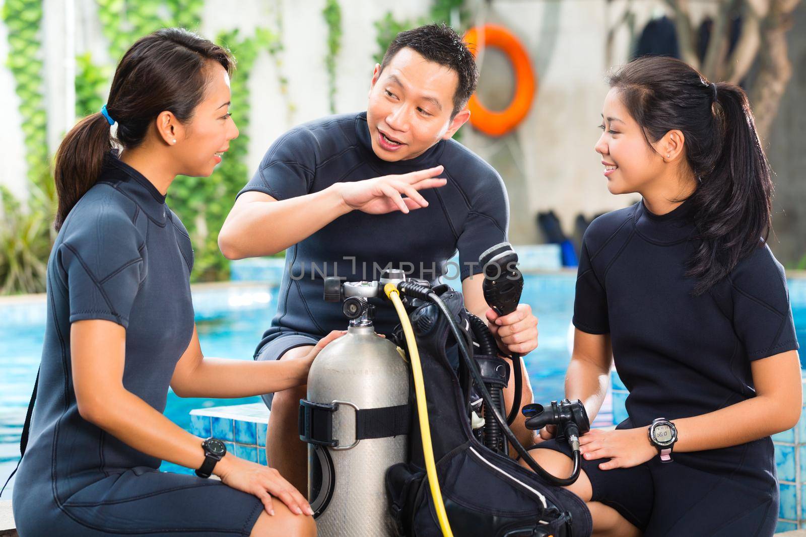 Asian people at the diver Course in diving school in wetsuit with an oxygen tank