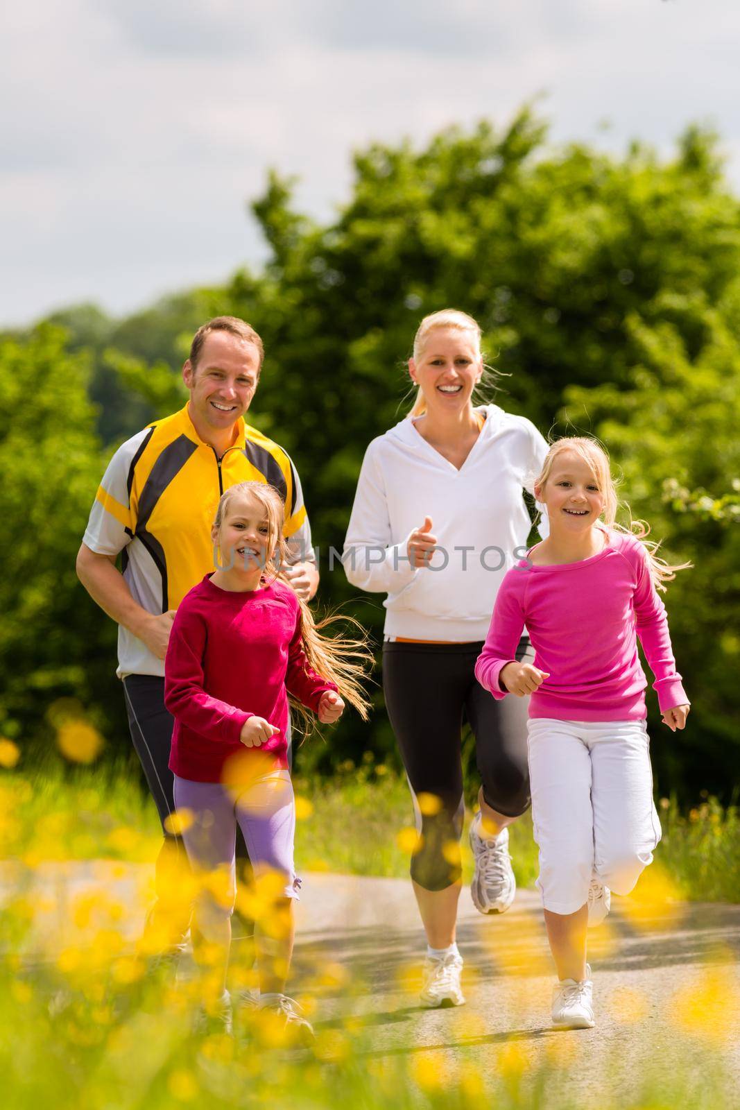 Family jogging for sport outdoors with the kids on summer day