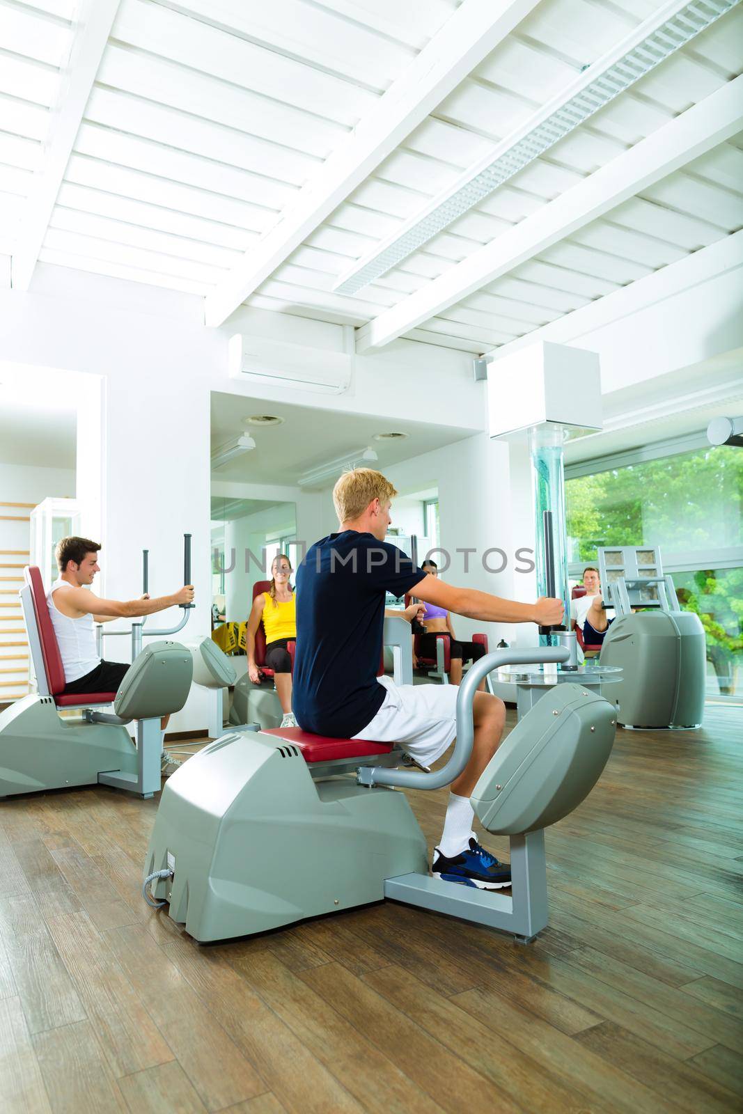 People in sport gym on machines by Kzenon