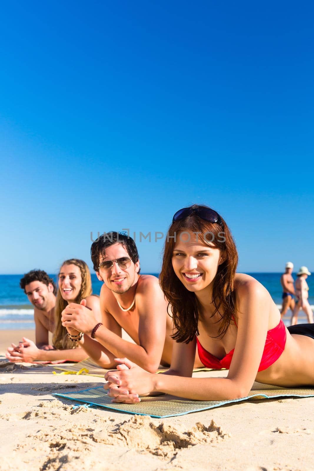 Friends on beach vacation in summer by Kzenon