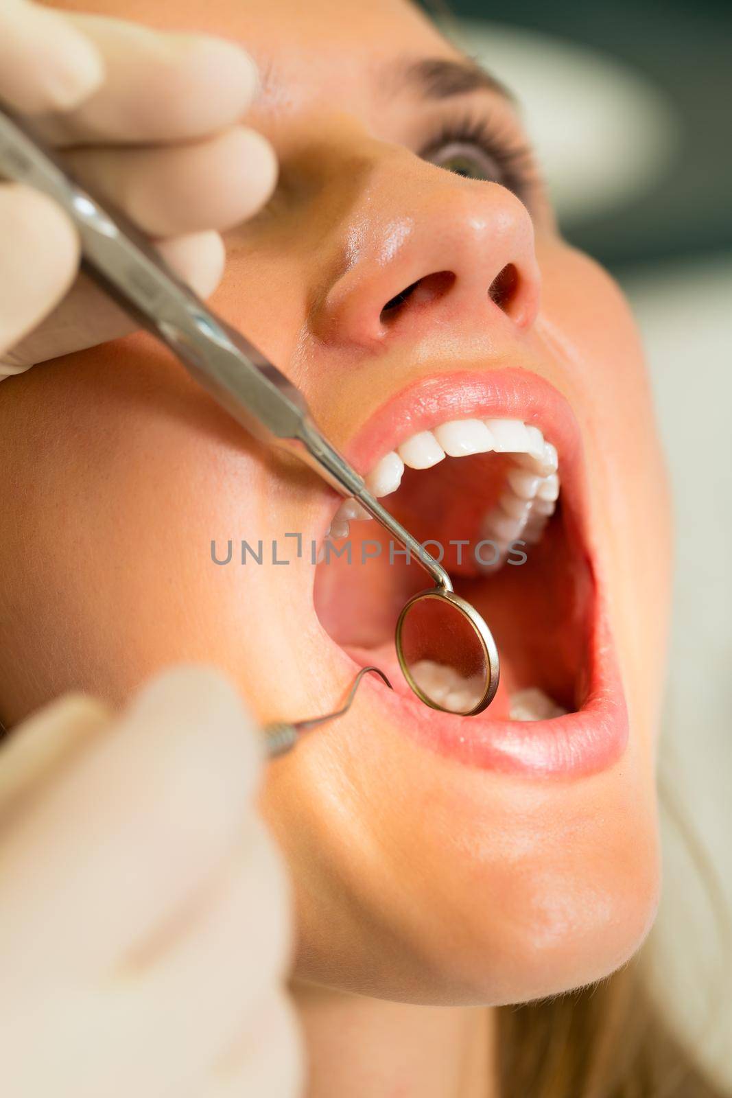 Female patient with dentist in a dental treatment, wearing gloves