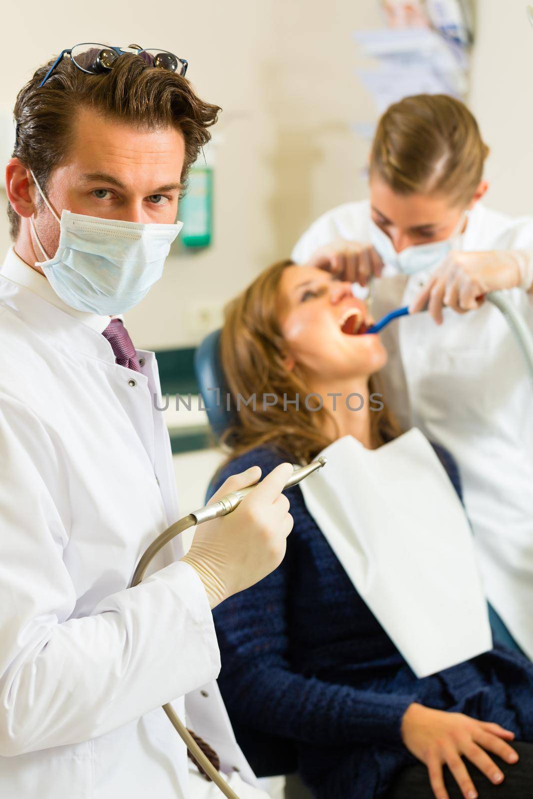 Dentist in his surgery, he holds a drill by Kzenon