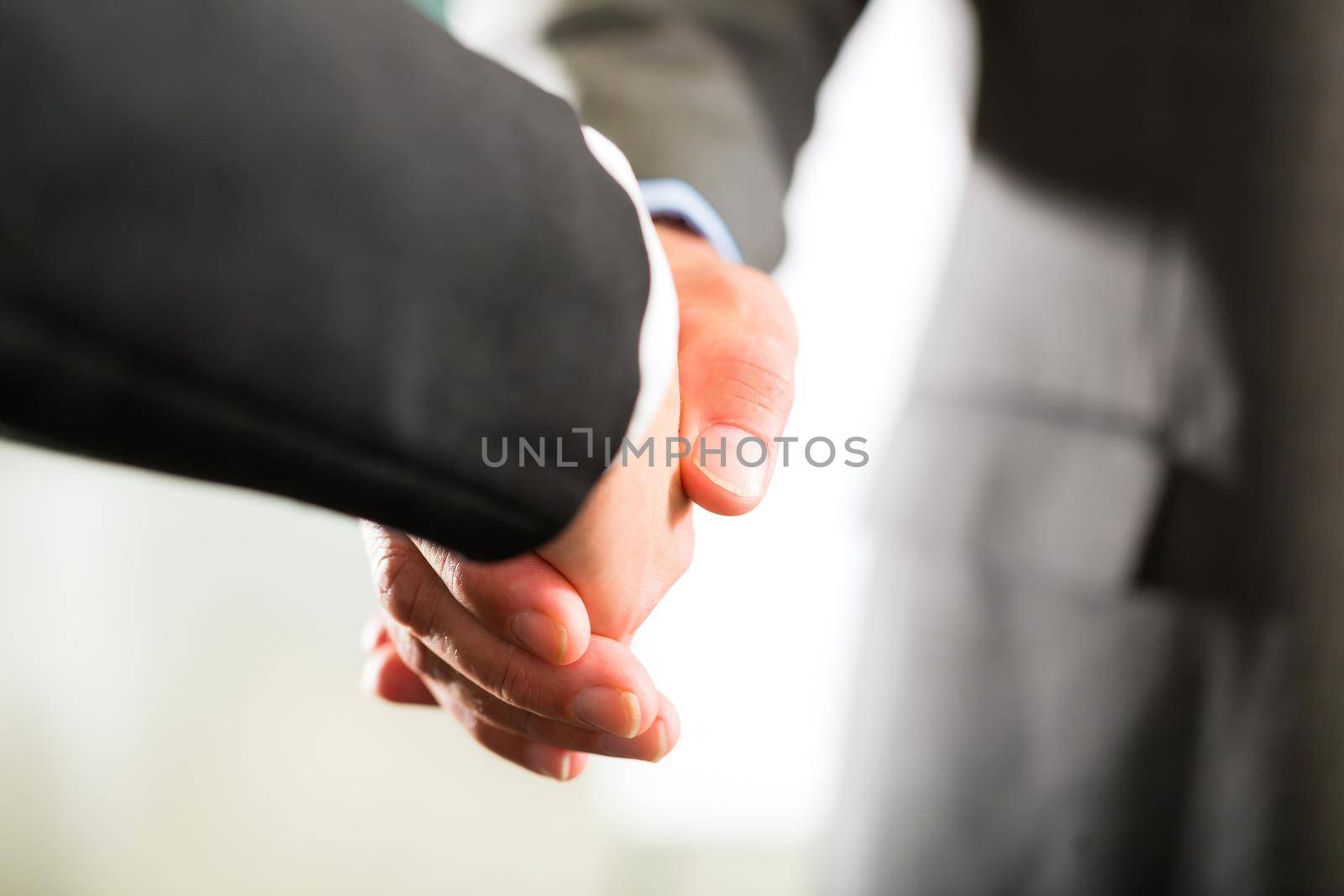 Business people doing Handshake by Kzenon