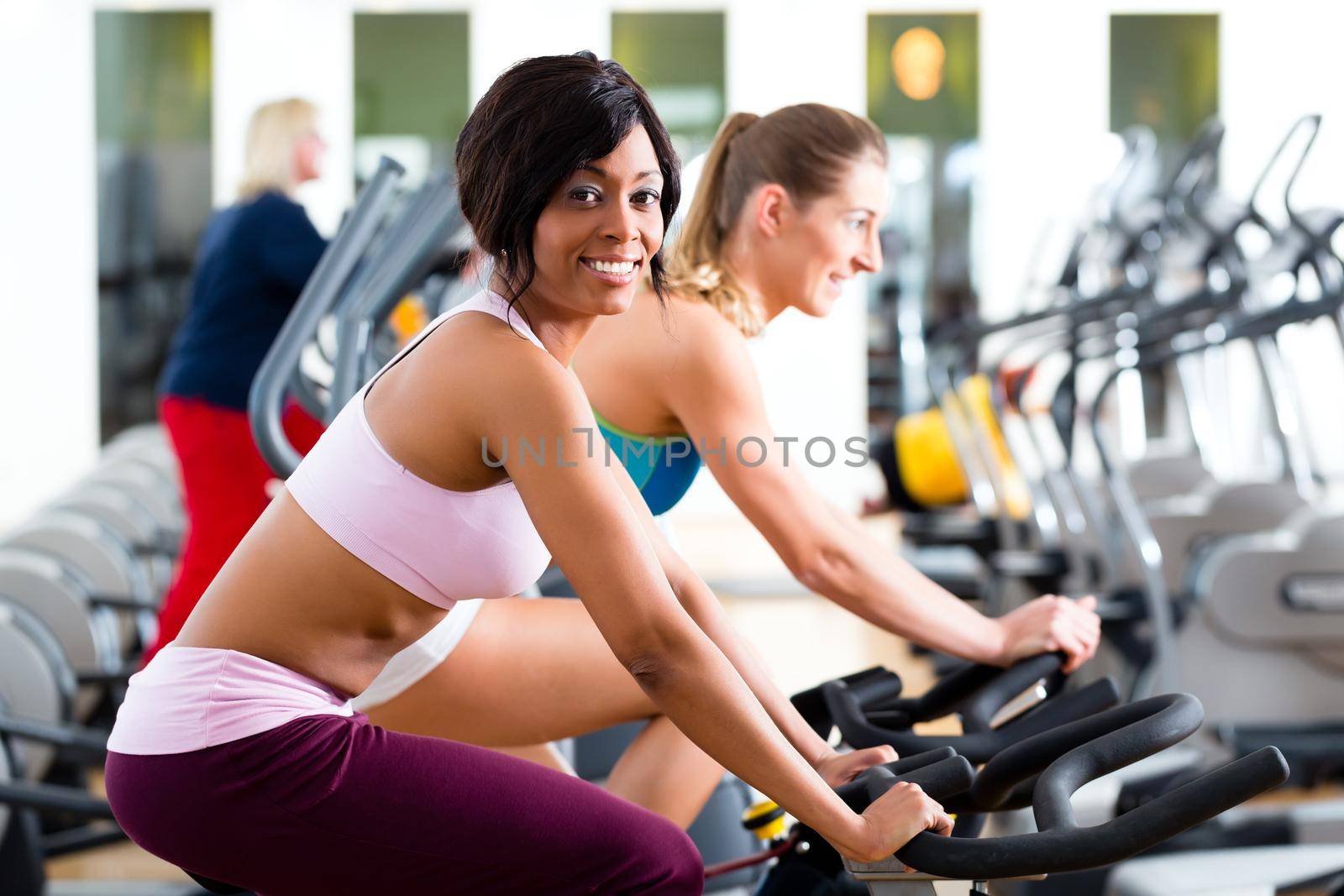 People Spinning in the gym on bicycles by Kzenon