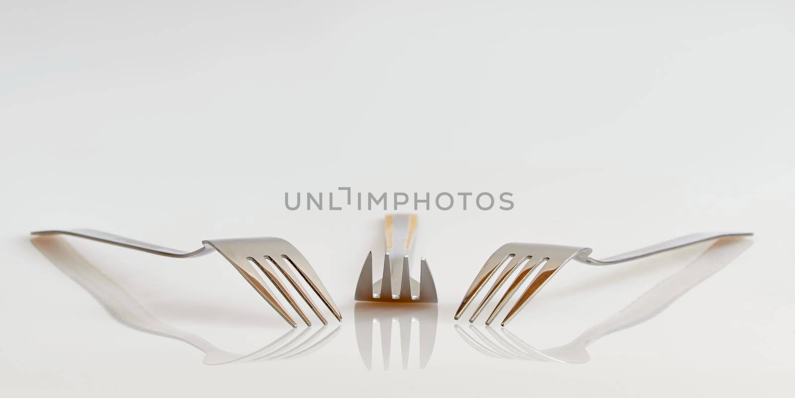 View of three forks with reflection and a clean background