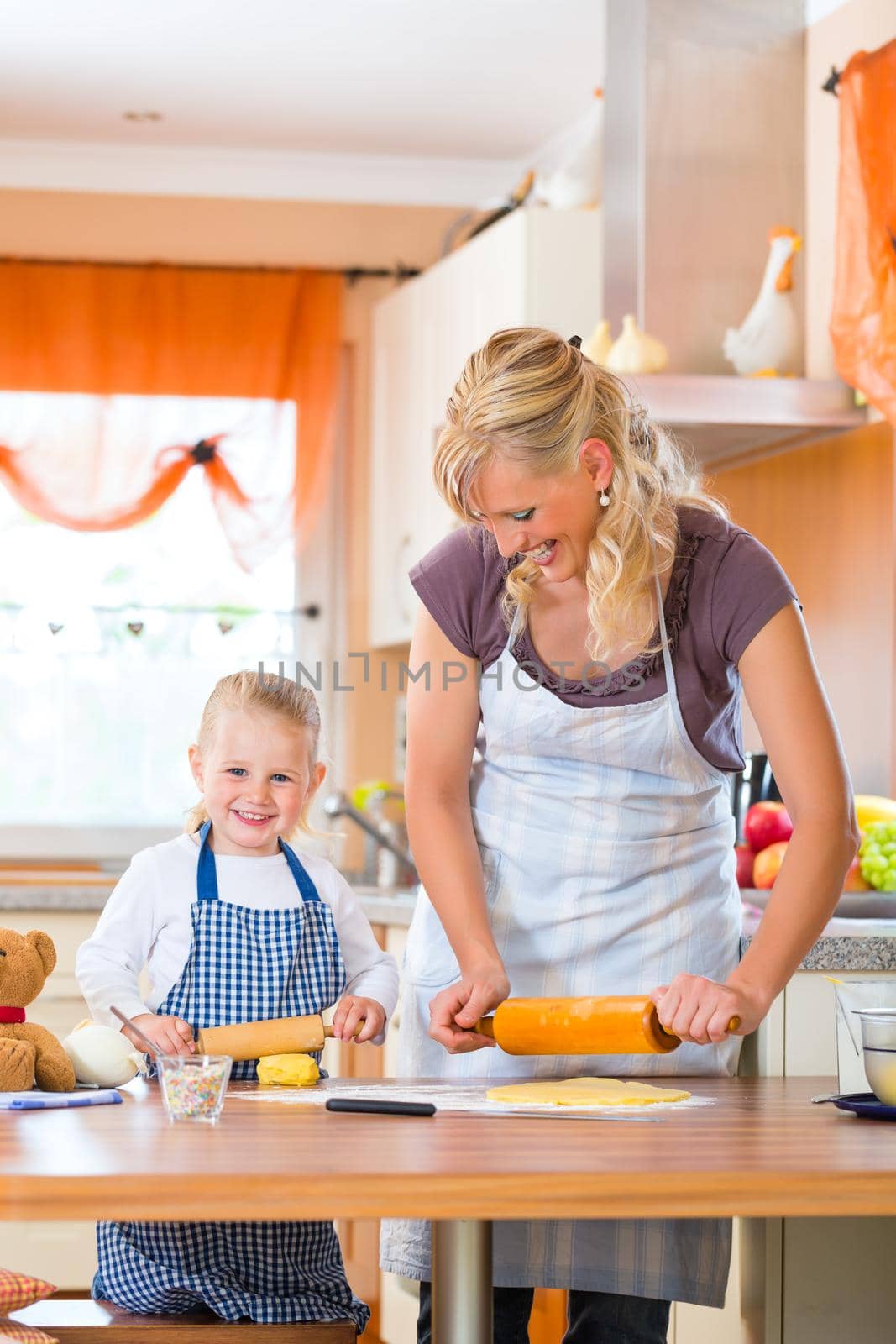 Mother and daughter baking cookies together by Kzenon