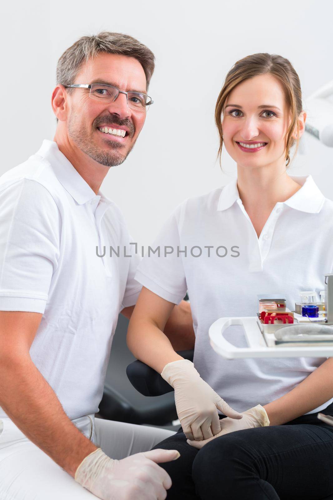 Successful Dentists in their surgery looking at the viewer standing side by side