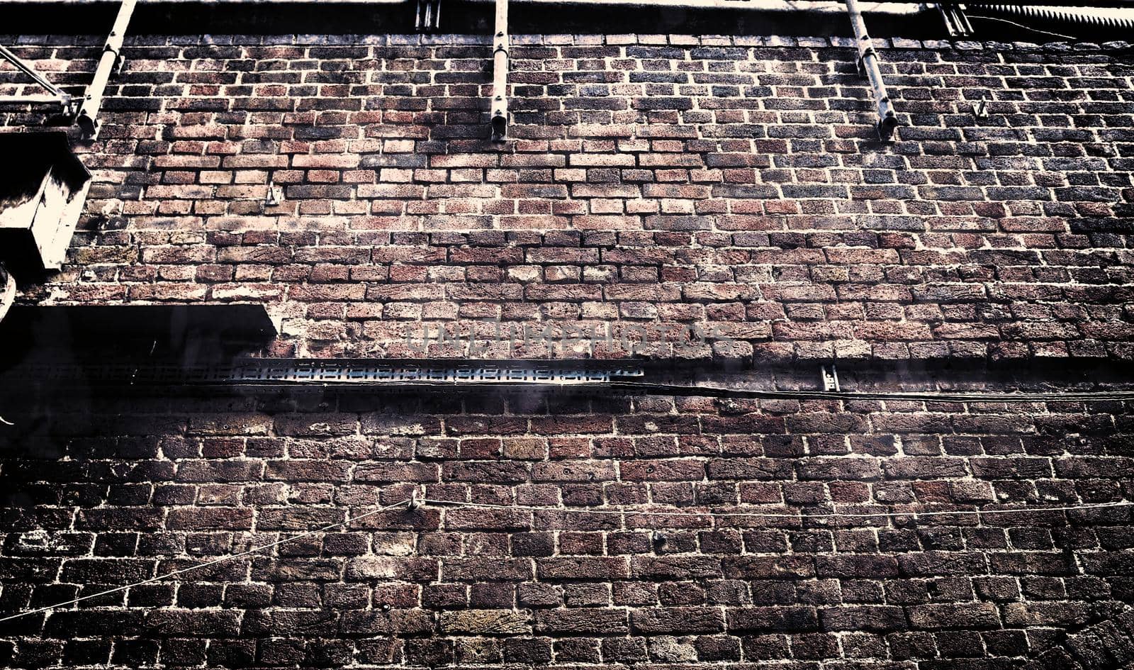 Aged and weathered old brick wall texture in a retro vintage design  by MP_foto71