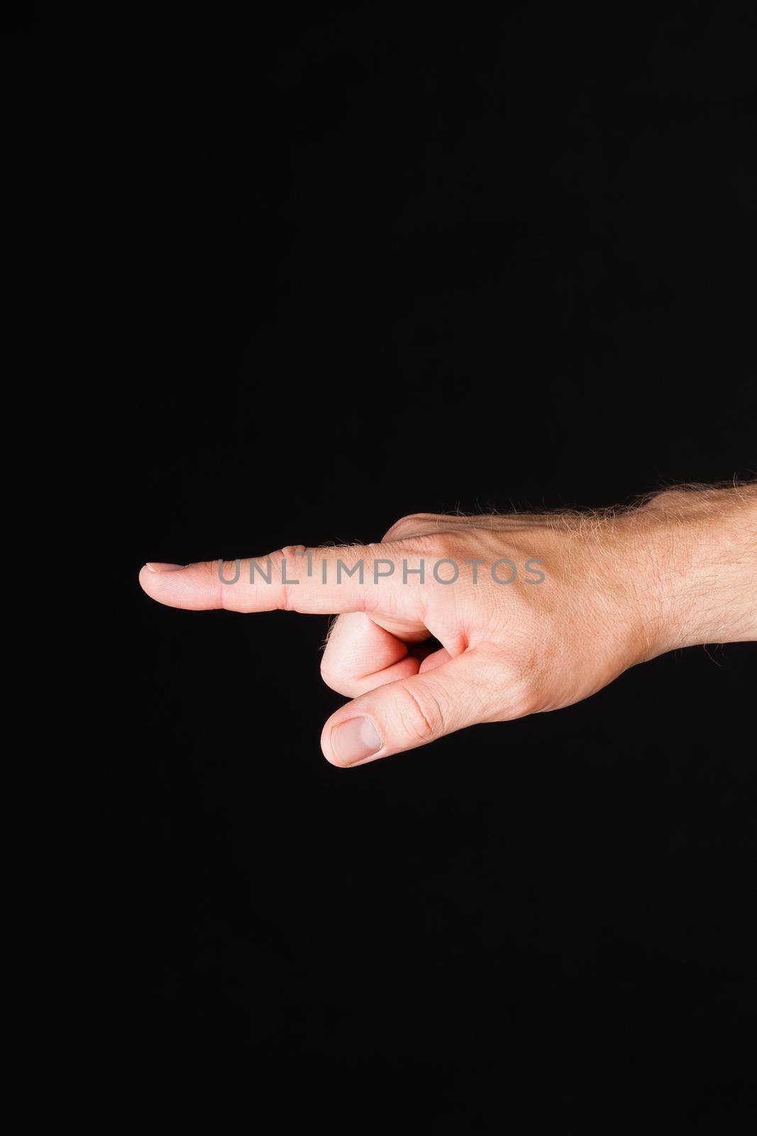 Male Caucasian hand showing blaming finger in front of black background