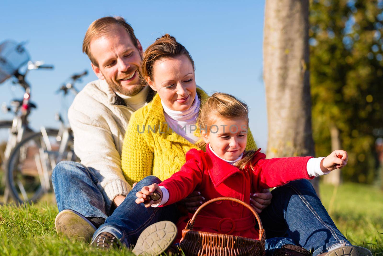 Family collecting chestnuts on bicycle trip by Kzenon