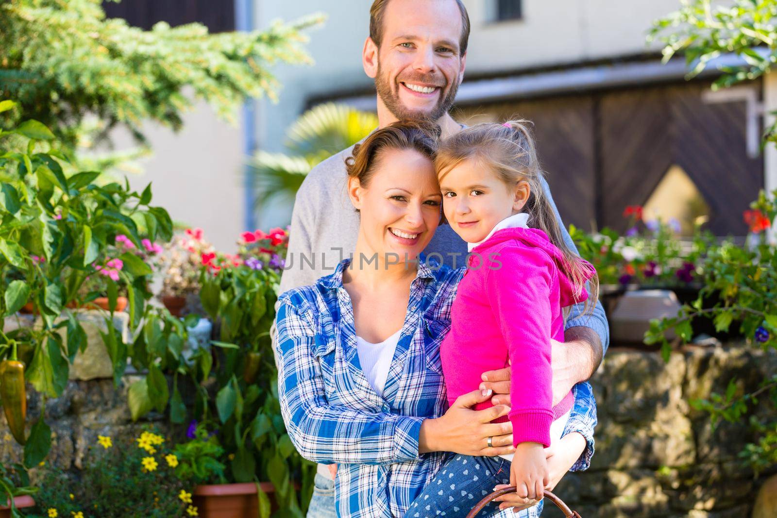 Mother, father and daughter in garden with basket