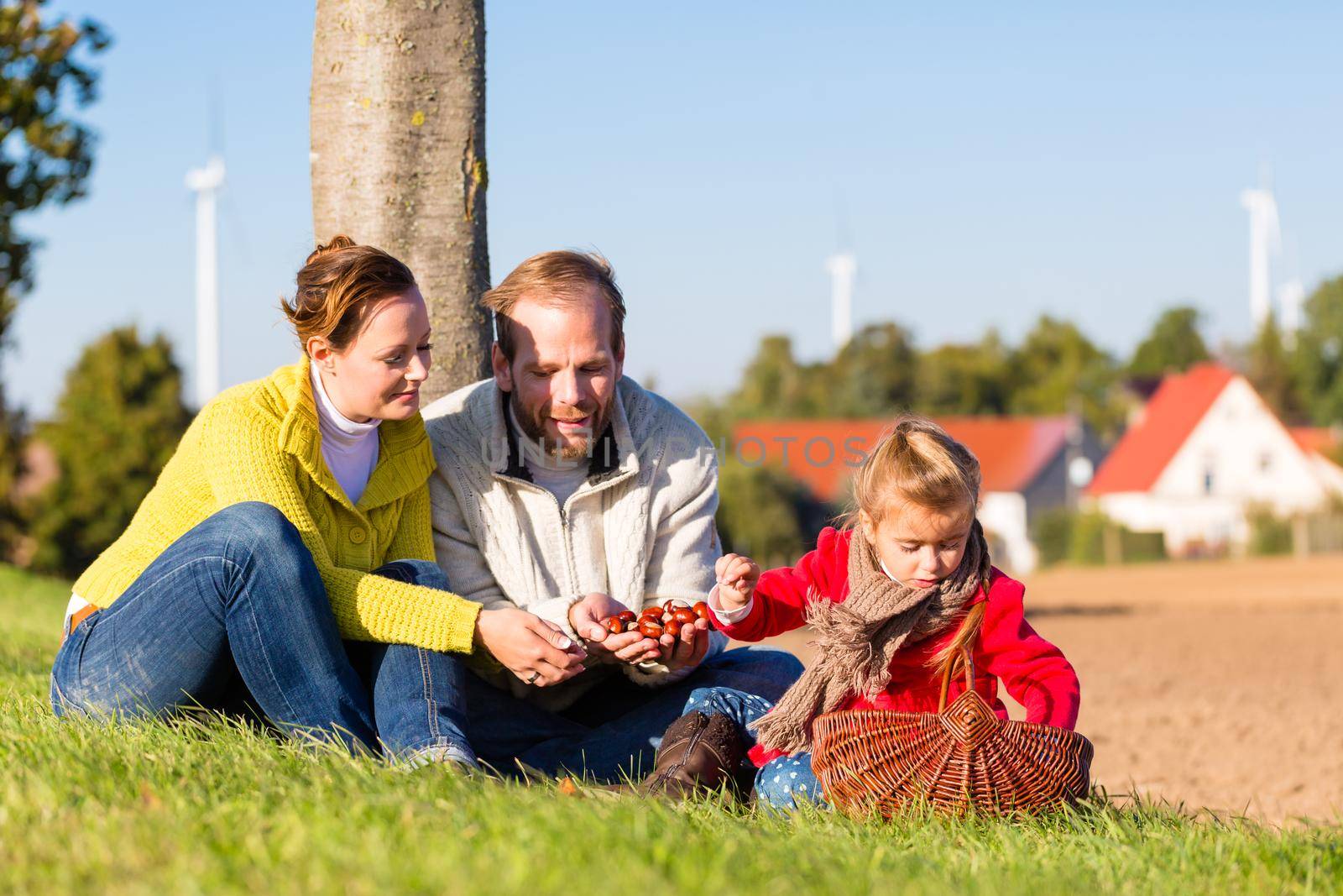 Family collecting chestnuts on bicycle trip by Kzenon